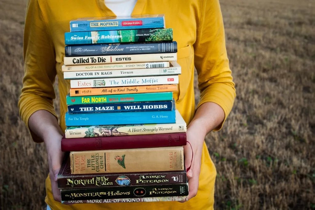 Woman holding stack old books